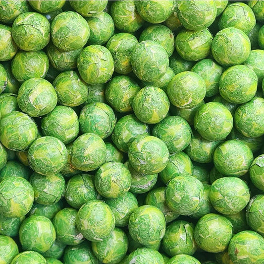 Milk chocolate Sprouts by Gummy Galaxy, a close-up of chocolate sprout candies in a clear bag, showcasing their smooth milk chocolate coating.